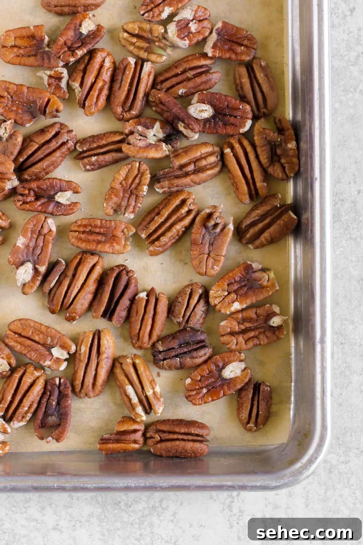 Cold Wild Rice Salad with Cranberries and Pecans 6 Roasted pecans on a baking sheet.