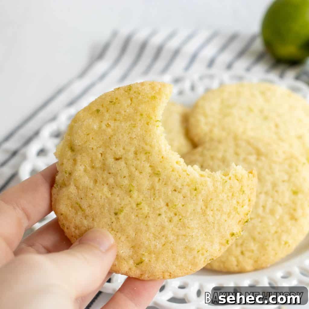 Soft Lime Sugar Cookies with Zesty Citrus Glaze 12 hand holding one of the lime sugar cookies missing a bite