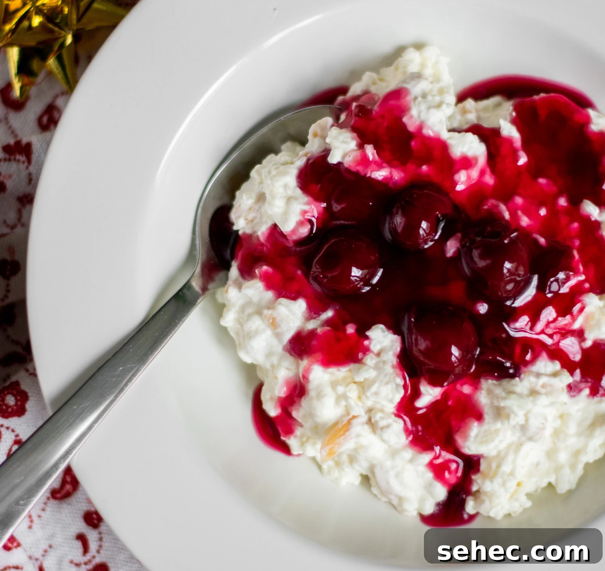 Risalamande Danish Rice Pudding with Almonds 10 Rice porridge with cherry sauce in a bowl.