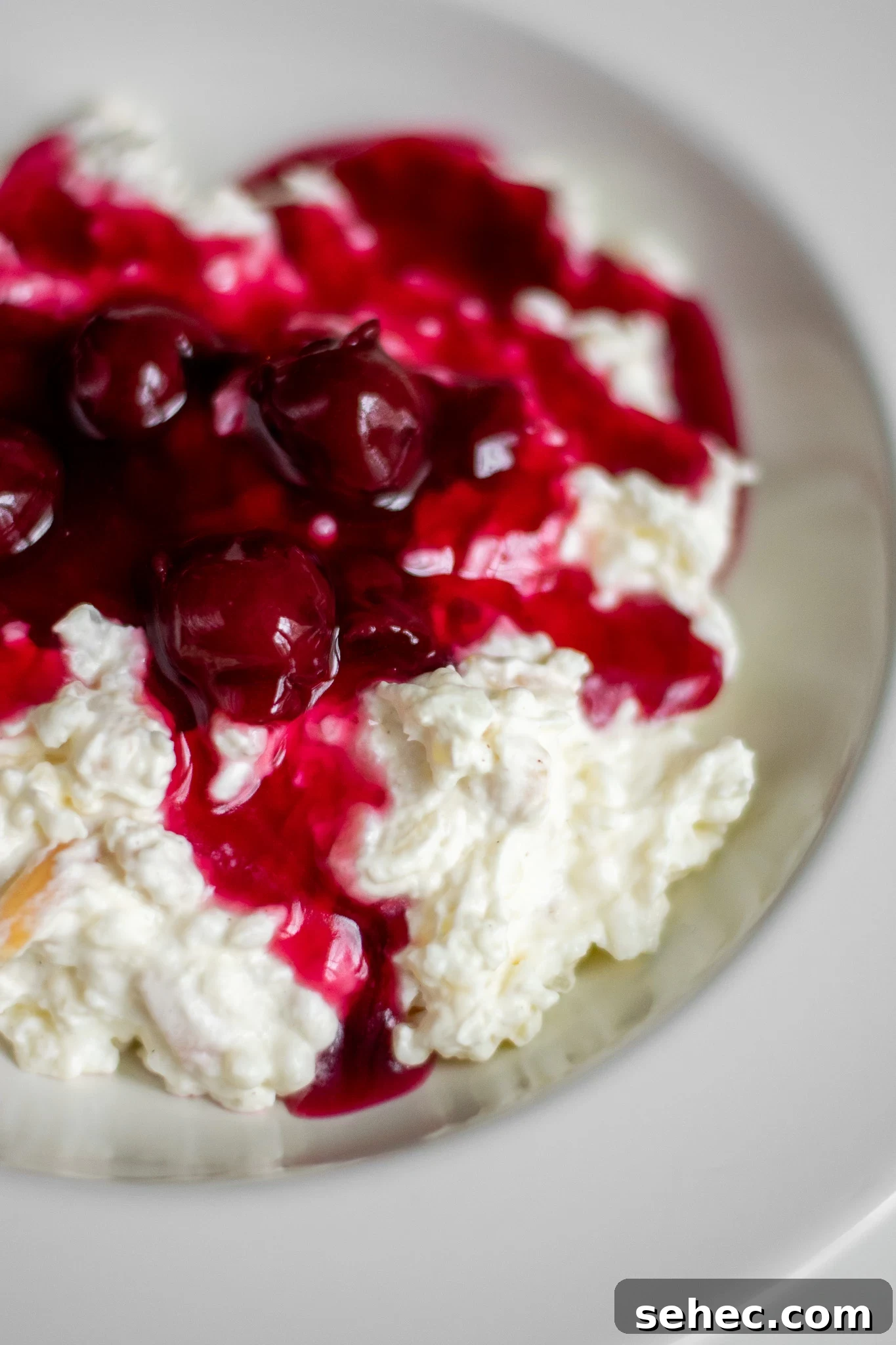 Risalamande Danish Rice Pudding with Almonds 2 Rice porridge with cherry sauce in a bowl.
