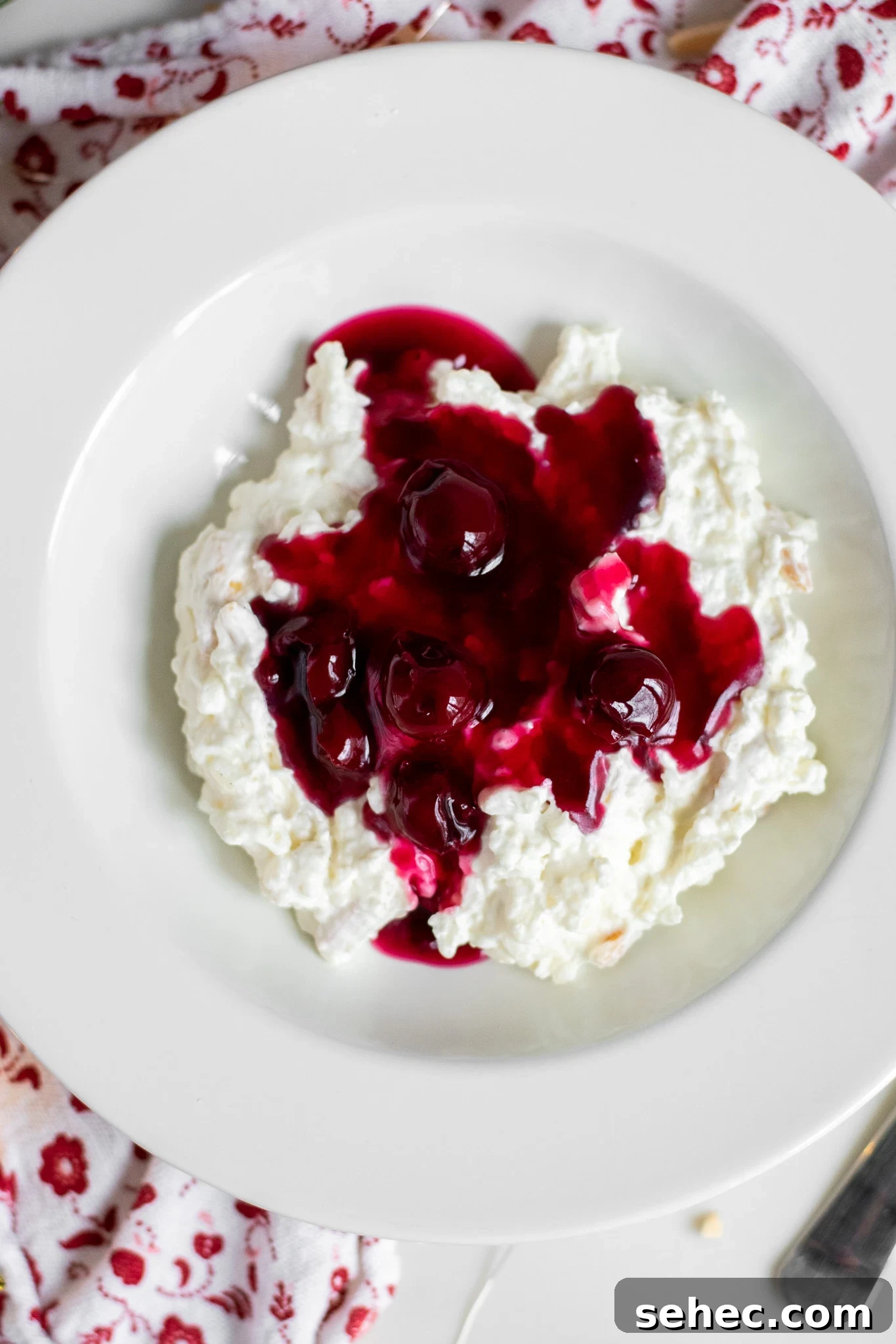 Risalamande Danish Rice Pudding with Almonds 7 Rice porridge with cherry sauce in a bowl.