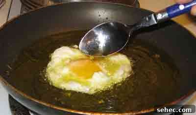 How to Fry Eggs Like a Greek Mom 4 Basting greek recipe fried eggs with oil.