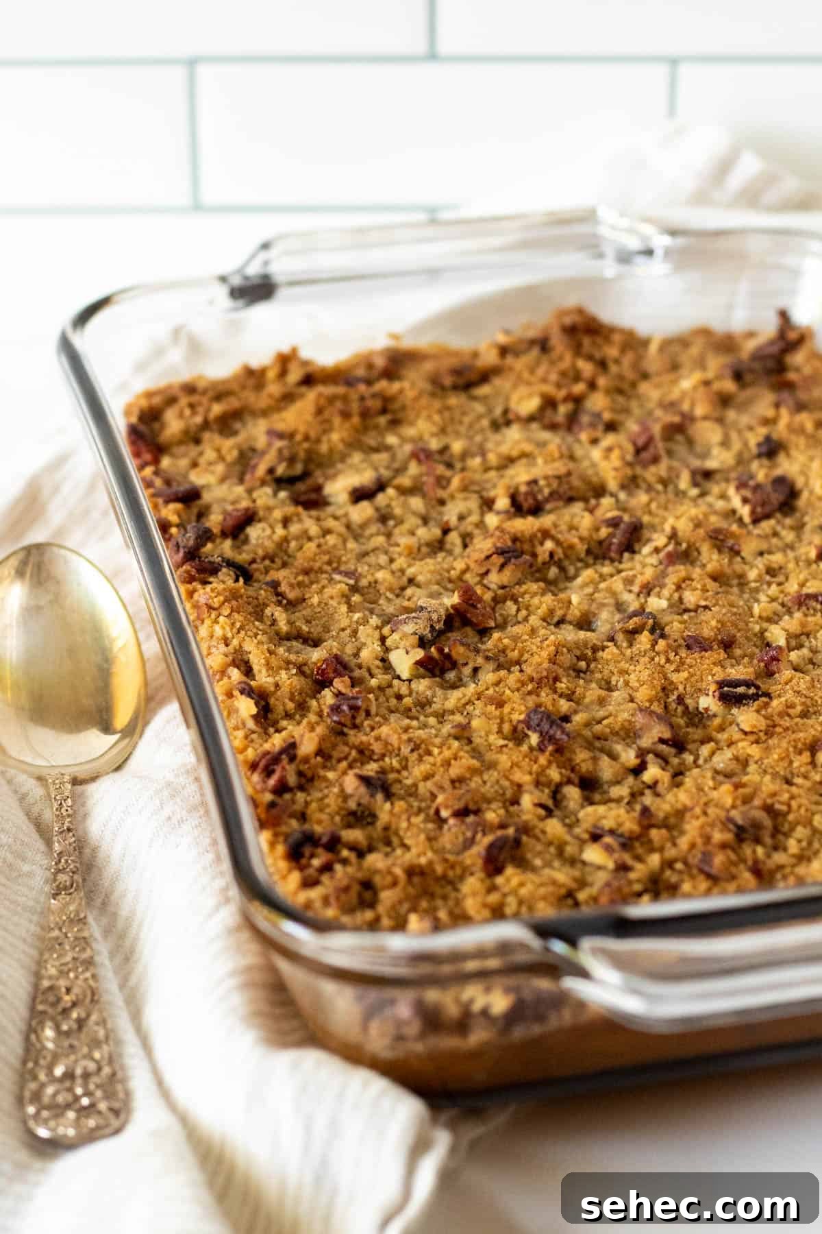 Classic Sweet Potato Casserole with Pecan Topping 2 Finished baked sweet potato casserole in a glass baking dish.