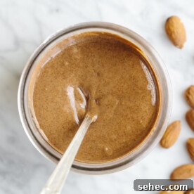 How to Make Almond Butter in 1 Minute 6 Almond butter in a glass jar with a spoon.