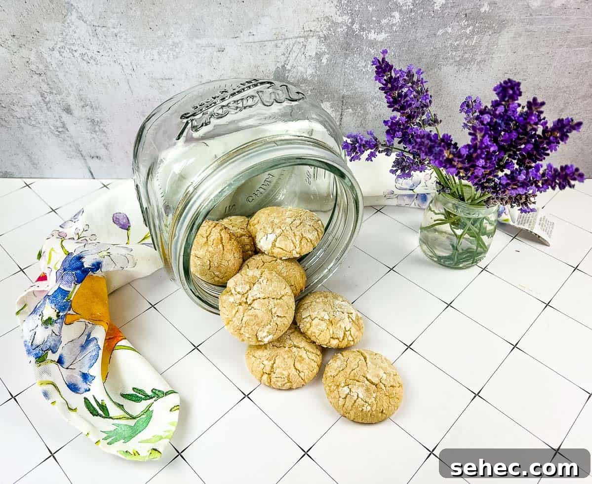 17 Buttery Fall Cookie Recipes for Cozy Shorter Days 15 A jar of White Chocolate Crinkle Cookies next to lavender flowers.