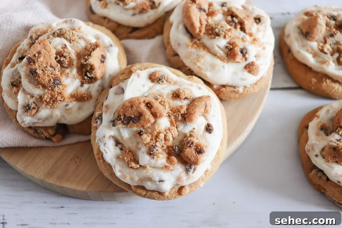 17 Buttery Fall Cookie Recipes for Cozy Shorter Days 6 Frosted chocolate chip cookie cookies on a wooden cutting board.