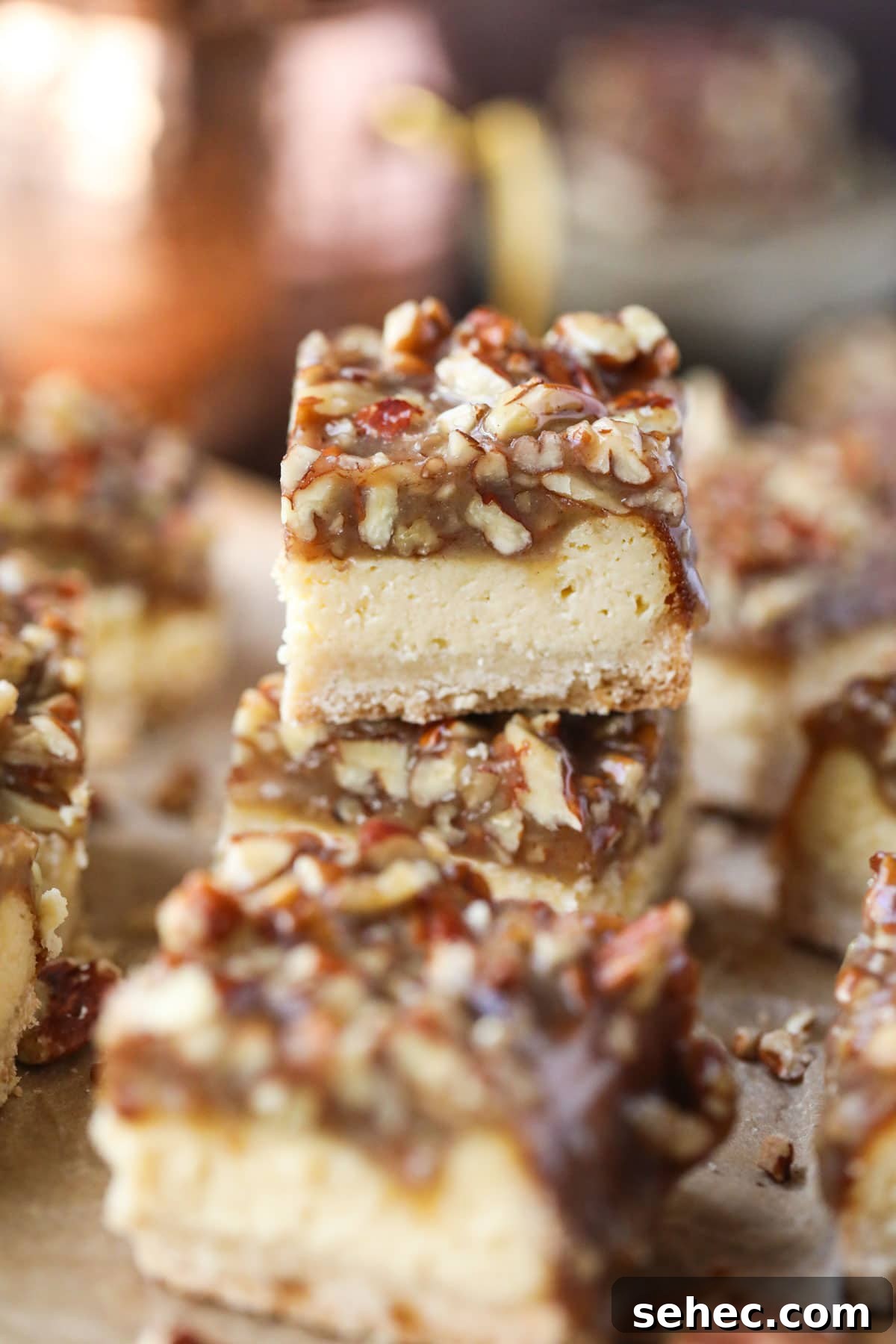 Pecan Pie Cheesecake Bars Recipe 6 pecan pie cheesecake bars on parchment paper.
