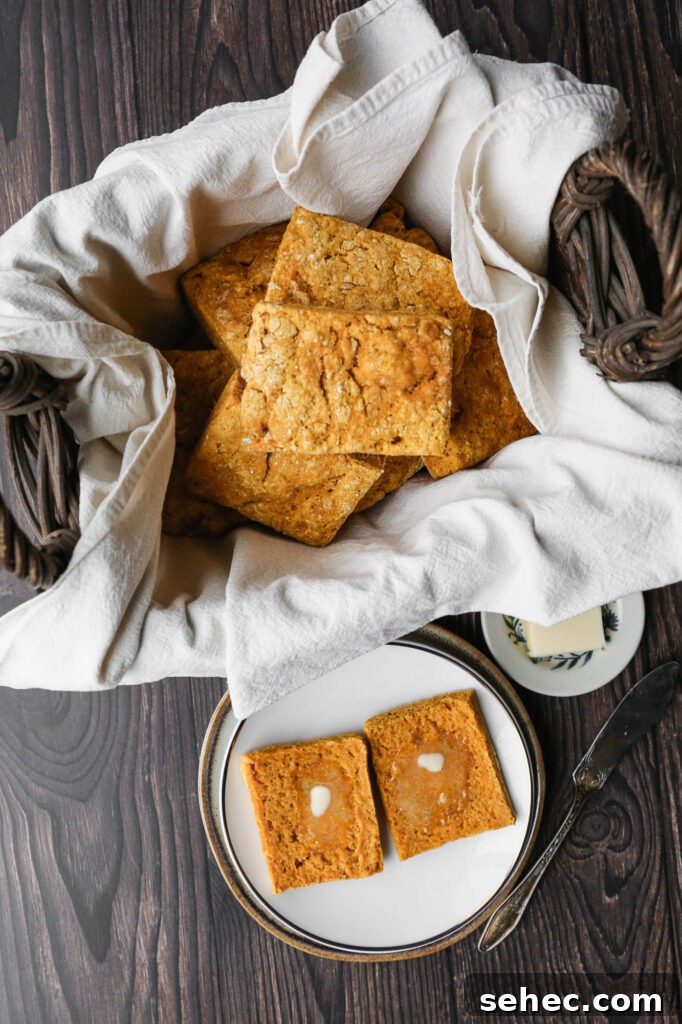 Gluten Free Sweet Potato Biscuits Recipe 2 a basket lined with a cream towel of gluten free sweet potato biscuits next to a plate with a biscuit cut in half with butter melting on top