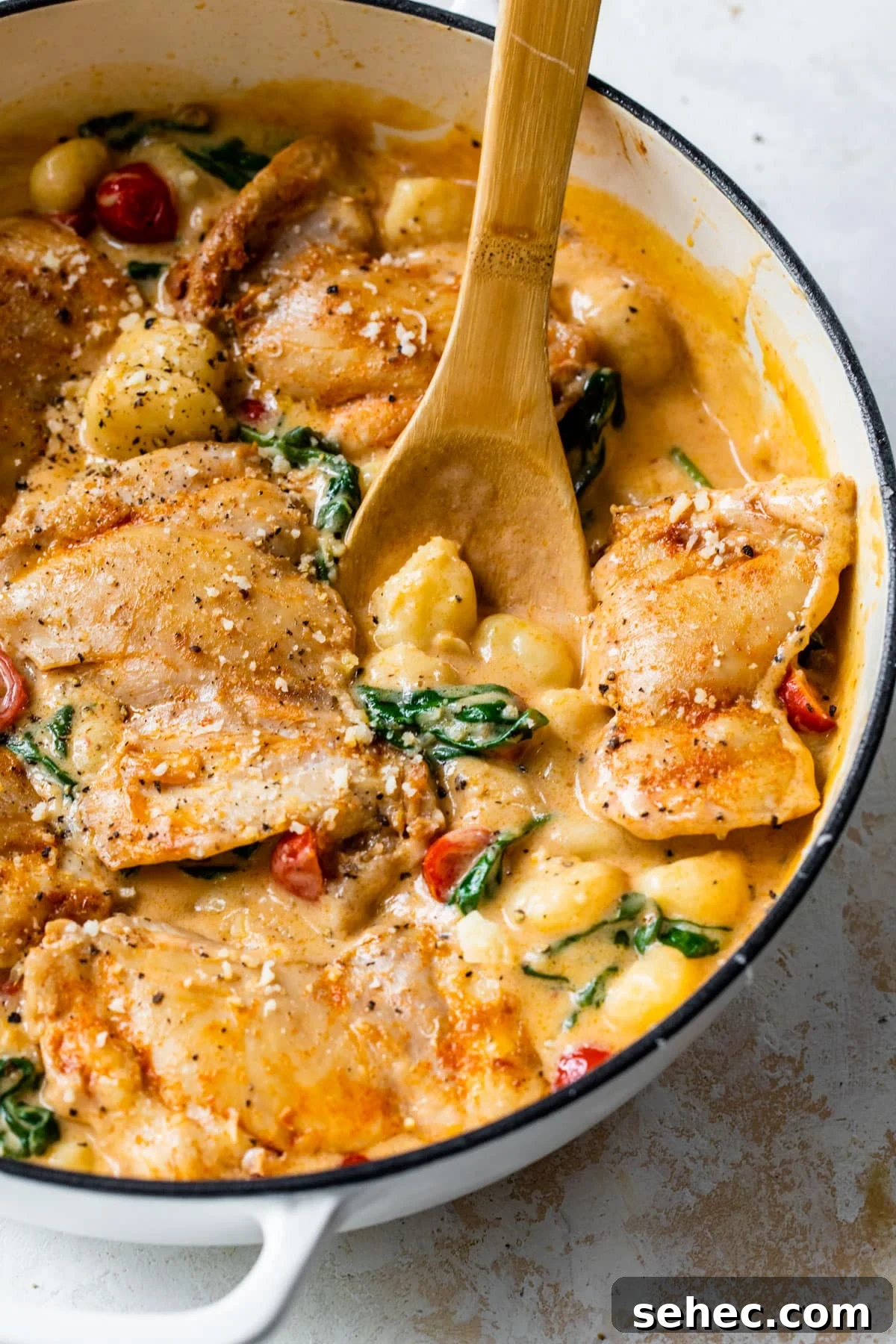 Creamy Chicken Gnocchi Skillet Recipe 7 cooked boneless chicken thighs in a skillet with gnocchi, tomatoes, and spinach in a cream sauce