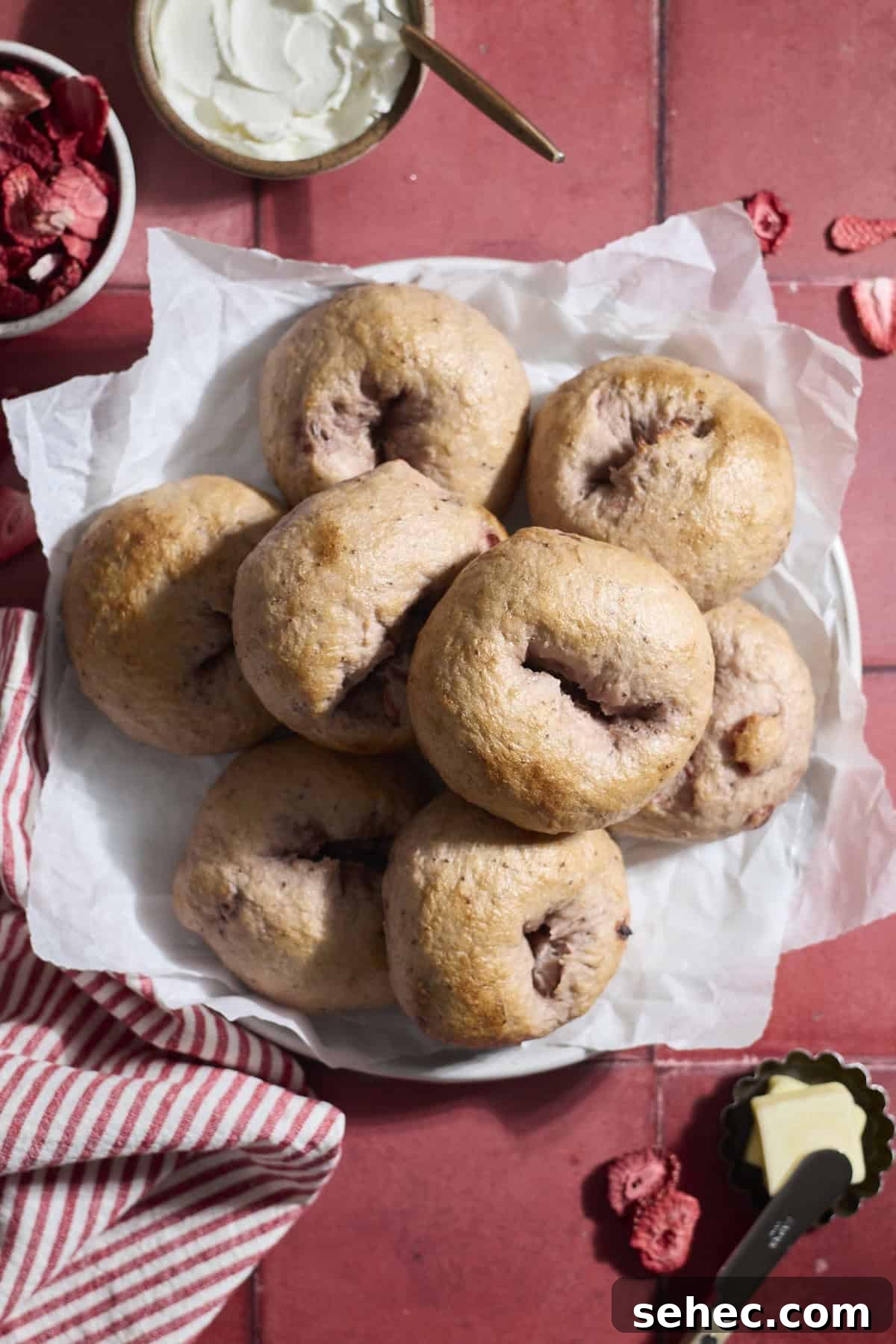 Strawberry Sourdough Discard Bagels 2 Sourdough Discard Strawberry Bagels on a white platter.