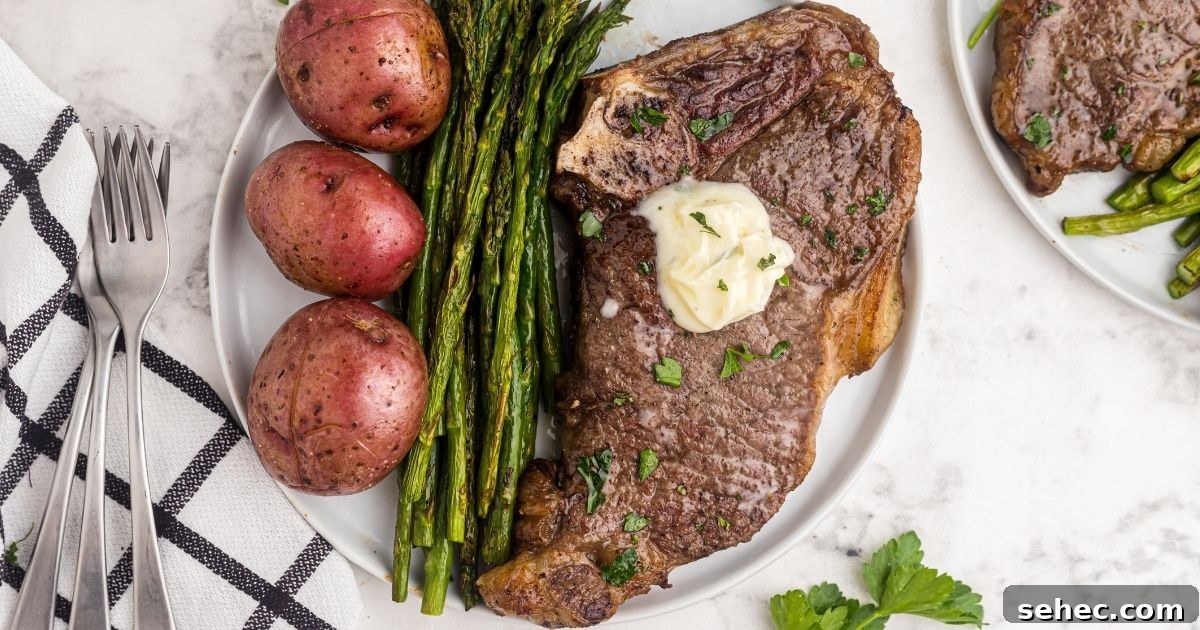 How to Reheat Steak in the Air Fryer 3 Juicy garlic steak on a white plate with asparagus and potatoes