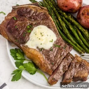 How to Reheat Steak in the Air Fryer 6 Juicy garlic steak on a white plate with asparagus and potatoes, the steak is sliced with a fork