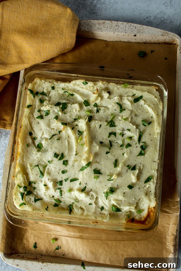 Ground Turkey Shepherds Pie Recipe 2 Fluffy, creamy mashed potatoes topped with fresh parsley top this Turkey shepherds pie on a baking sheet.