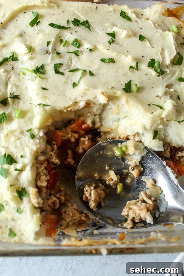 Ground Turkey Shepherds Pie Recipe 7 A large spoon digging into freshly made healthy turkey shepherds pie.