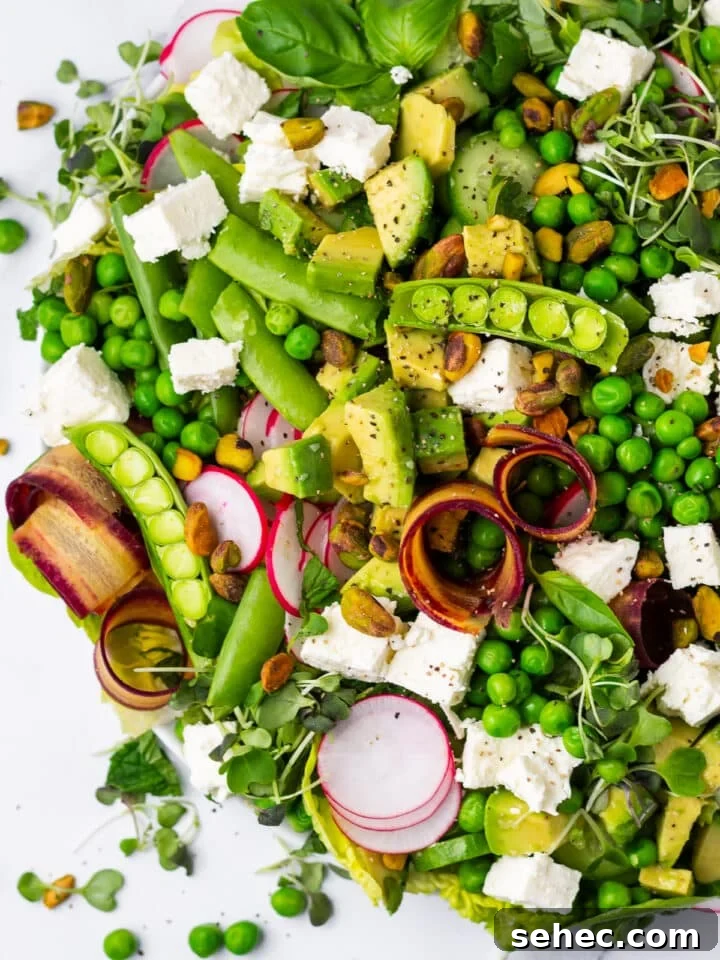 Spring Pea Salad with Lemon Mint Vinaigrette 13 close up view of snap peas, feta, carrot curls and thinly sliced radish on a spring pea salad