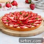 French Strawberry Custard Tart Recipe 11 Close up on the strawberry tart placed over a wooden round board.
