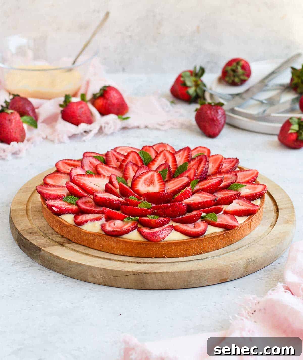 French Strawberry Custard Tart Recipe 9 Tart on a round wooden board.
