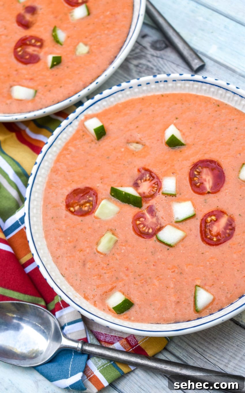 Homemade Gazpacho Recipe with Fresh Tomatoes 2 homemade gazpacho topped with diced cucumber and tomato in two white bowls