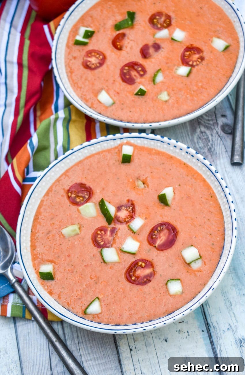 Homemade Gazpacho Recipe with Fresh Tomatoes 6 homemade gazpacho topped with diced cucumber and tomato in two white bowls