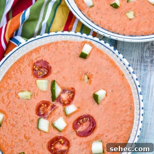 Homemade Gazpacho Recipe with Fresh Tomatoes 8 homemade gazpacho topped with diced cucumber and tomato in two white bowls