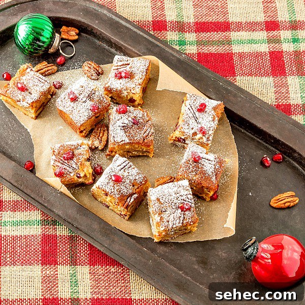 Christmas Sorghum Blondies with Pomegranate and Pecans 2 A platter of blondies with pecans and pomegranate arils and Christmas decorations.