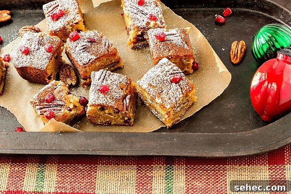 Christmas Sorghum Blondies with Pomegranate and Pecans 5 Sorghum blondies on brown parchment paper on a platter.