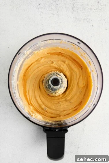 Homemade Cheese Spread Recipe 4 A food processor filled with blended cheese spread.