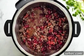 Instant Pot Chili Recipe 4 Sauteed beef with beer, beef stock, and kidney beans mixed together inside Instant Pot.