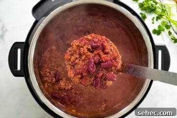 Instant Pot Chili Recipe 6 Scoop of Beef and Bean Instant Pot Chili being ladled out of Instant Pot.
