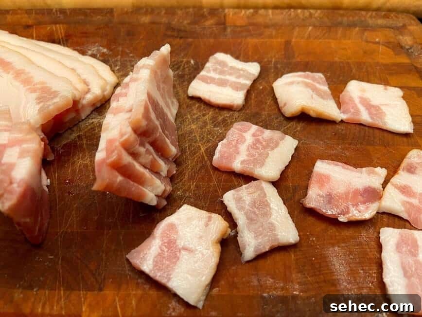 Julia Child Beef Bourguignon Recipe Made Simple 7 Cut bacon pieces on a wood cutting board.