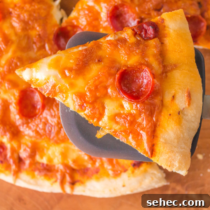 Crispy Chewy Sourdough Pizza Crust Recipe 17 A slice of baked pepperoni pizza over a full sourdough pizza