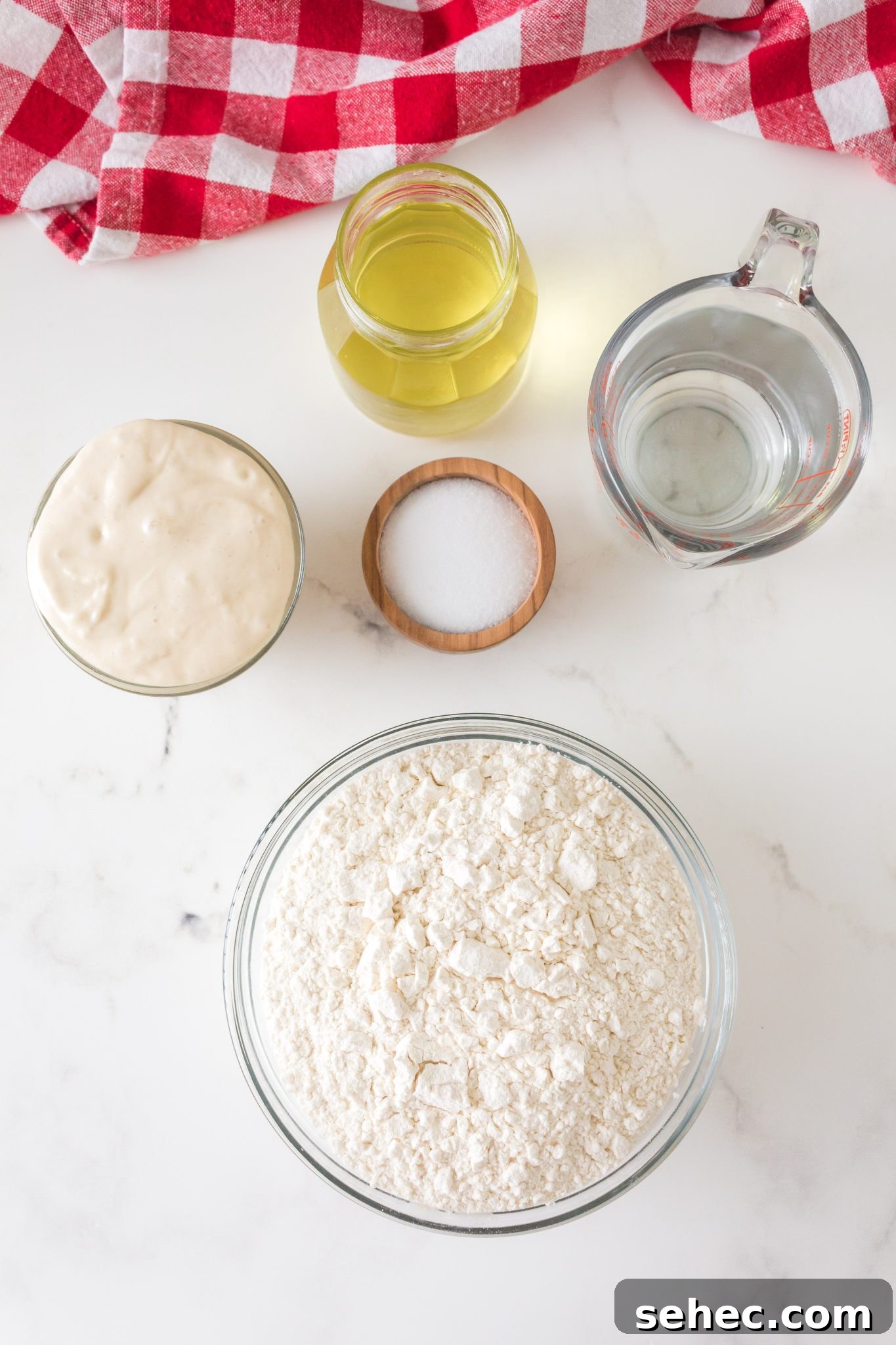 Crispy Chewy Sourdough Pizza Crust Recipe 3 Ingredients for sourdough pizza crust including flour, olive oil, bubbly starter, salt, and water