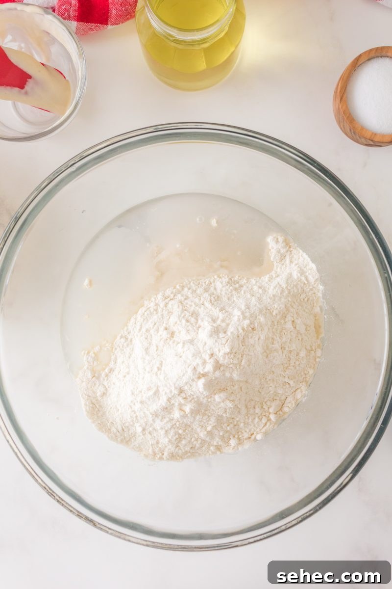 Crispy Chewy Sourdough Pizza Crust Recipe 5 Flour added to sourdough starter and water for pizza dough