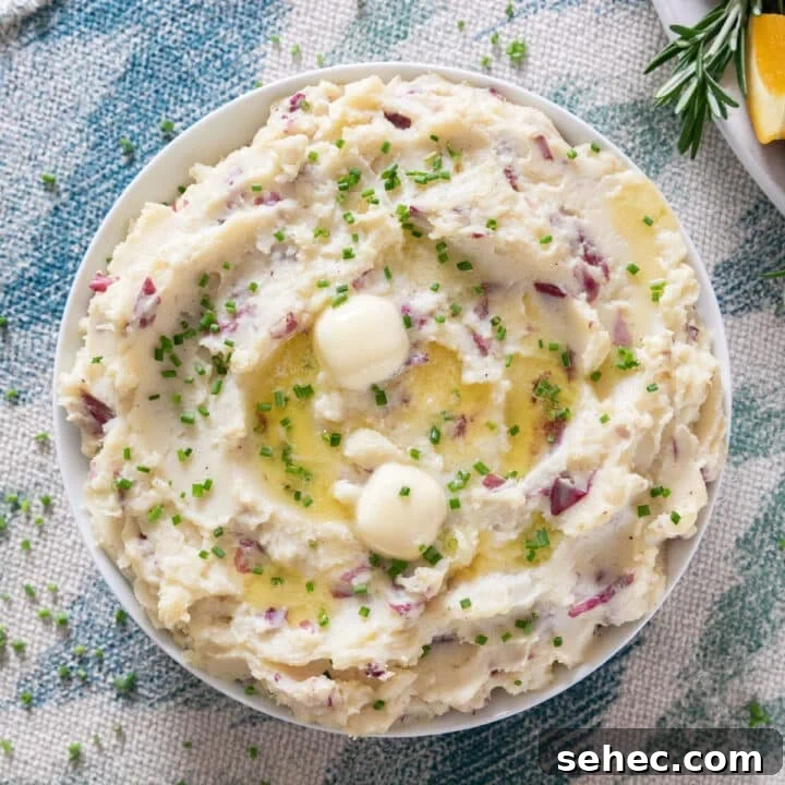 An overhead image of mashed potatoes with melting butter and chives on top.