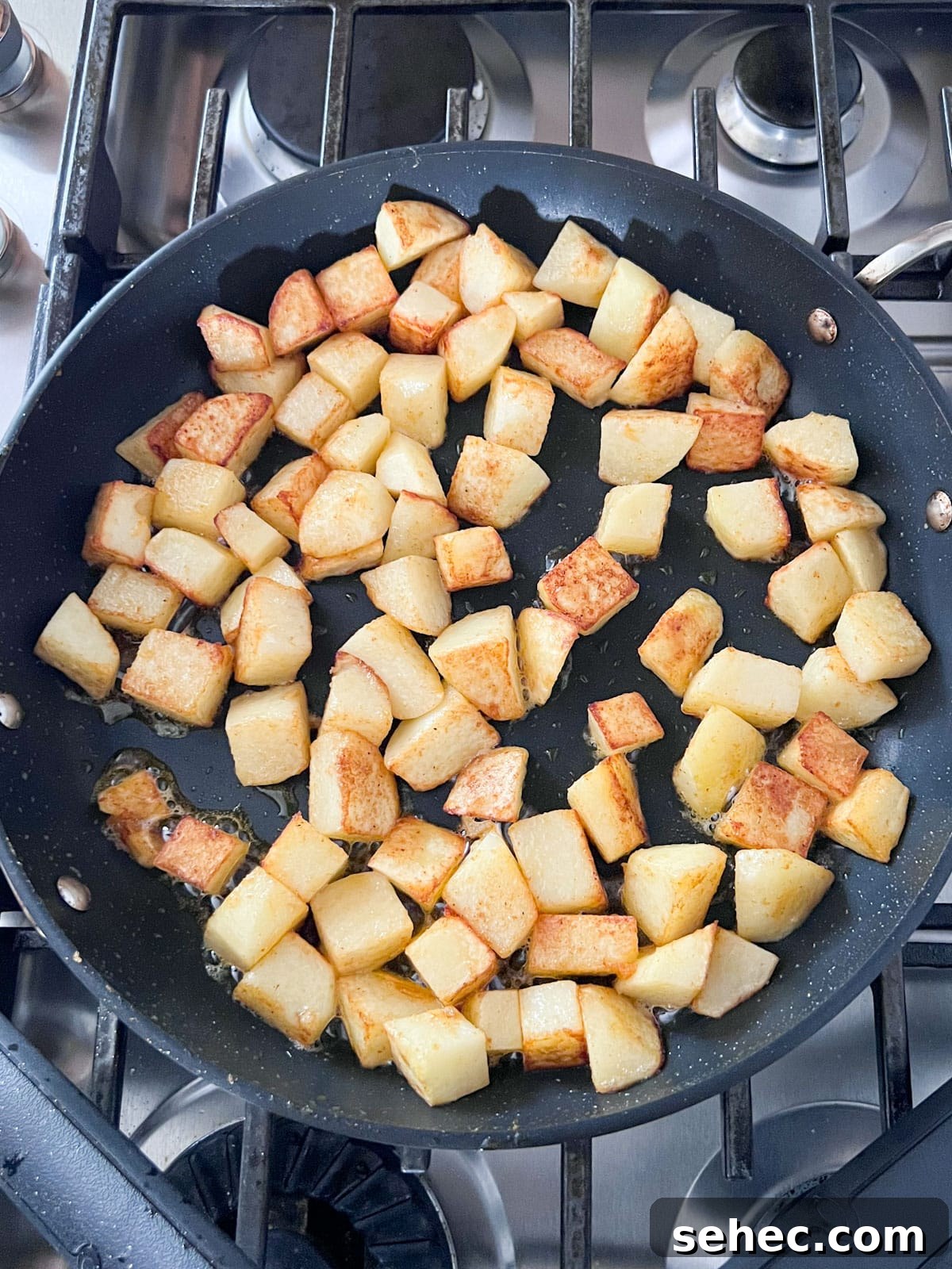 Crispy Fried Potatoes Recipe 6 Potatoes starting to brown in a large pan.