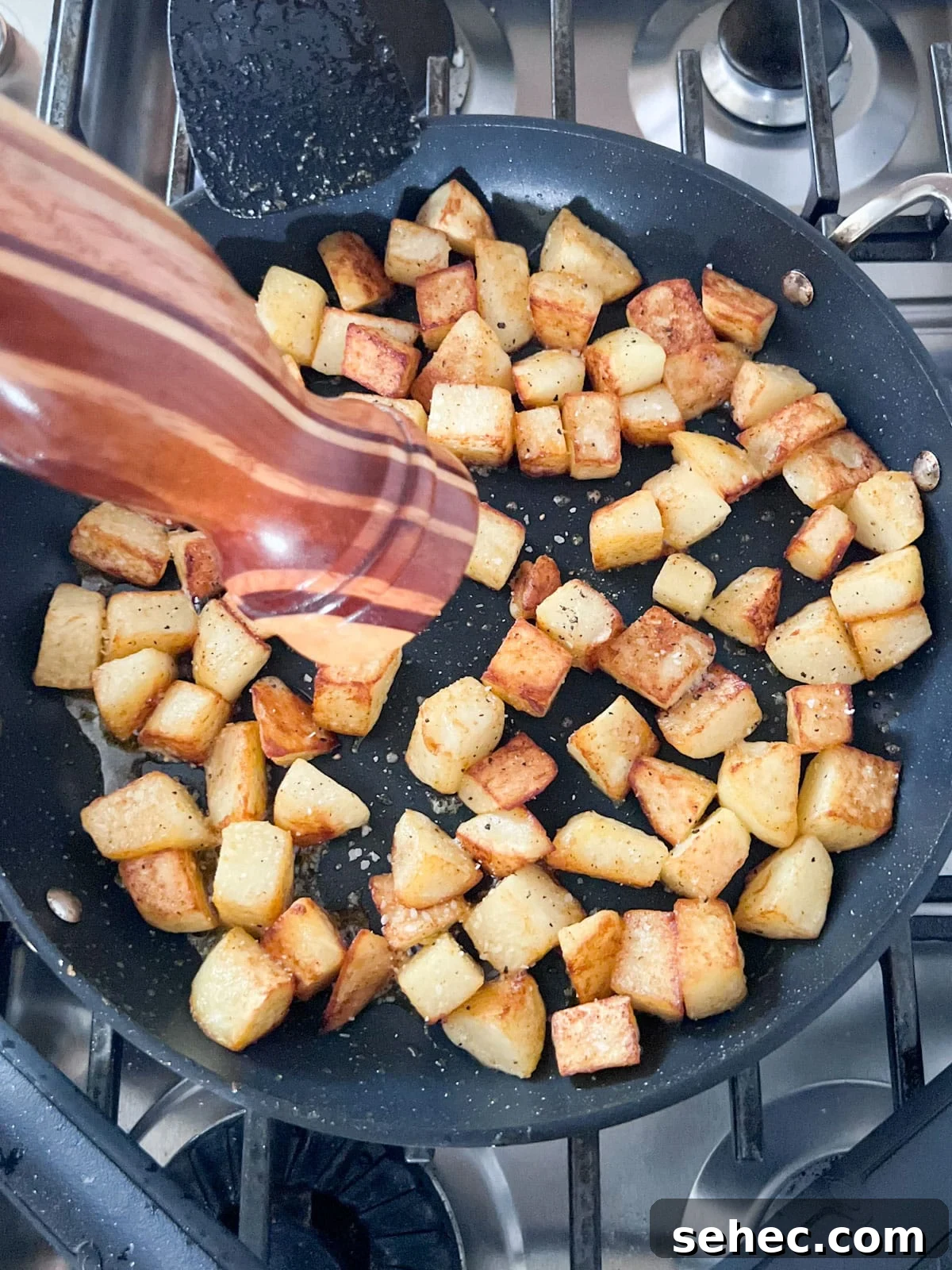 Crispy Fried Potatoes Recipe 7 A pepper grinder grinding black pepper in to the pan of potatoes.