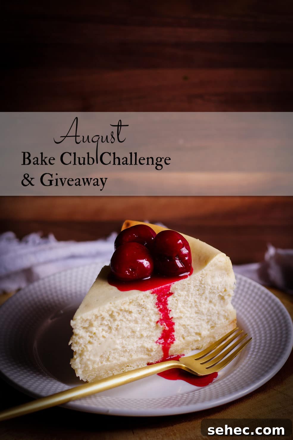 August 2021 Bake Club Challenge 2 A thick slice of New York Cheesecake with cherry sauce on top on a white plate with a gold fork.
