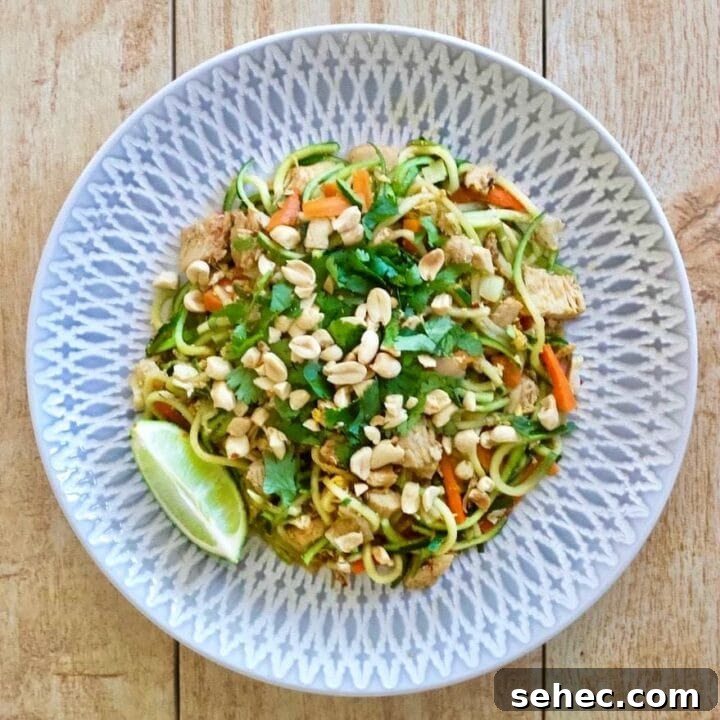 Plate of zucchini noodles with chicken, peanuts, carrots, and pad Thai sauce