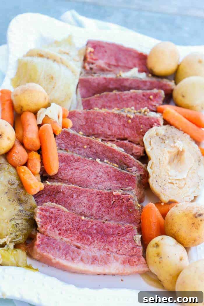 Slow Cooker Corned Beef and Cabbage Recipe 2 Slow Cooker Corned Beef and Cabbage on white platter with carrots and potatoes