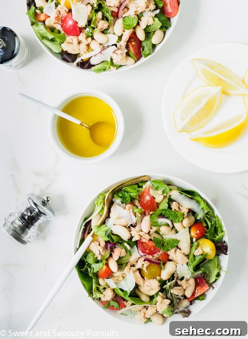 Mediterranean White Bean and Tuna Salad 3 Bowls of white bean and tuna salad served with lemon and olive oil dressing on the side.