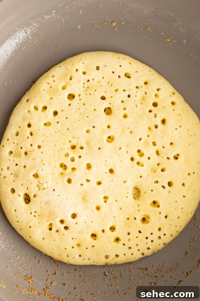 Baghrir Moroccan Semolina Pancakes with Honeycomb Holes 7 a pancake in a frying pan