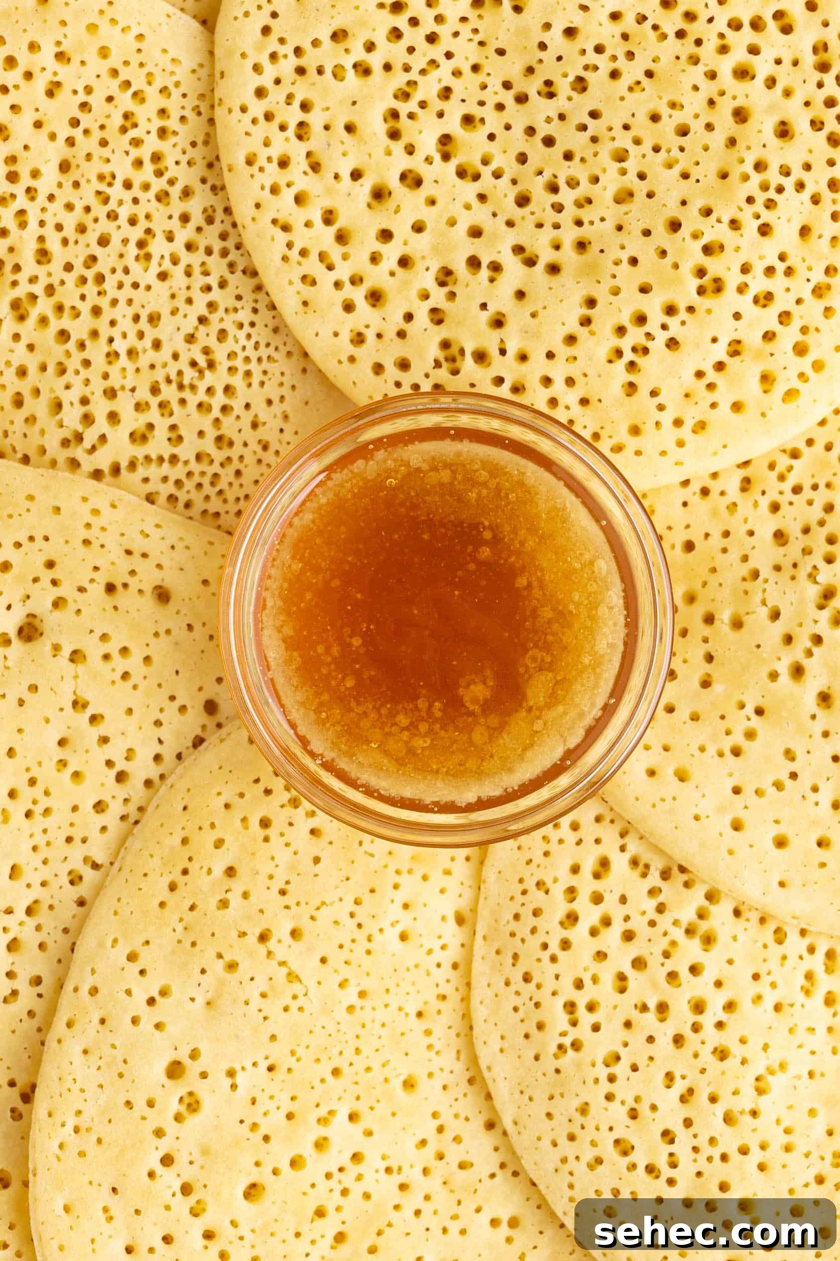 Baghrir Moroccan Semolina Pancakes with Honeycomb Holes 10 moroccan pancakes on a plate with honey