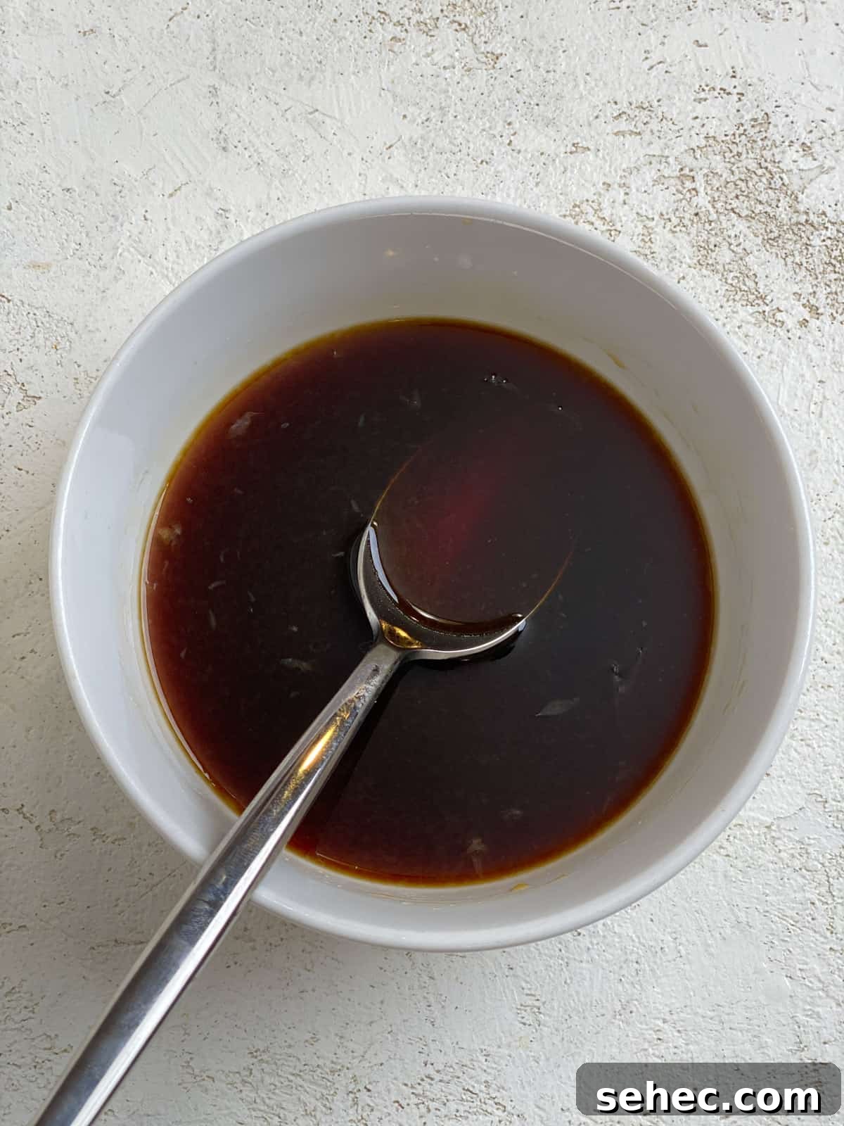 Lemon Basil Tofu Recipe with Crispy Edges 5 process of mixing soy sauce mixture in small white bowl