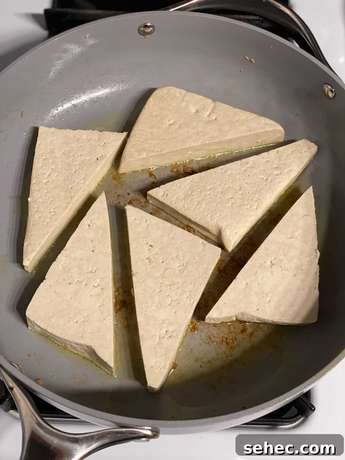 Lemon Basil Tofu Recipe with Crispy Edges 7 process of adding triangular tofu in pan