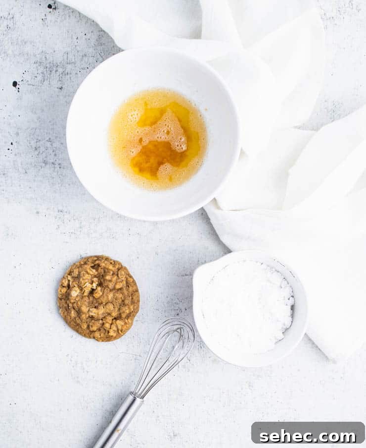 Pumpkin Oatmeal Cookies with Brown Butter Icing 5 a baked pumpkin oatmeal cookie next to a bowl of browned butter and powdered sugar.