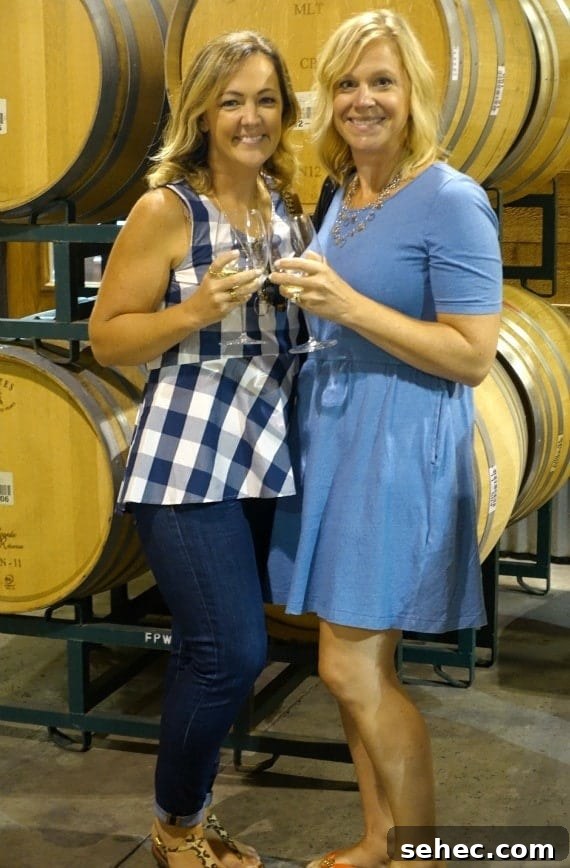 California Coastal Cruise – Santa Barbara Christie and Shelly holding glasses of Chardonnay and smiling at Fess Parker Winery