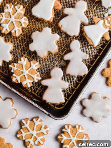 Snowflakes and gingerbread women are decorated on baking sheets.