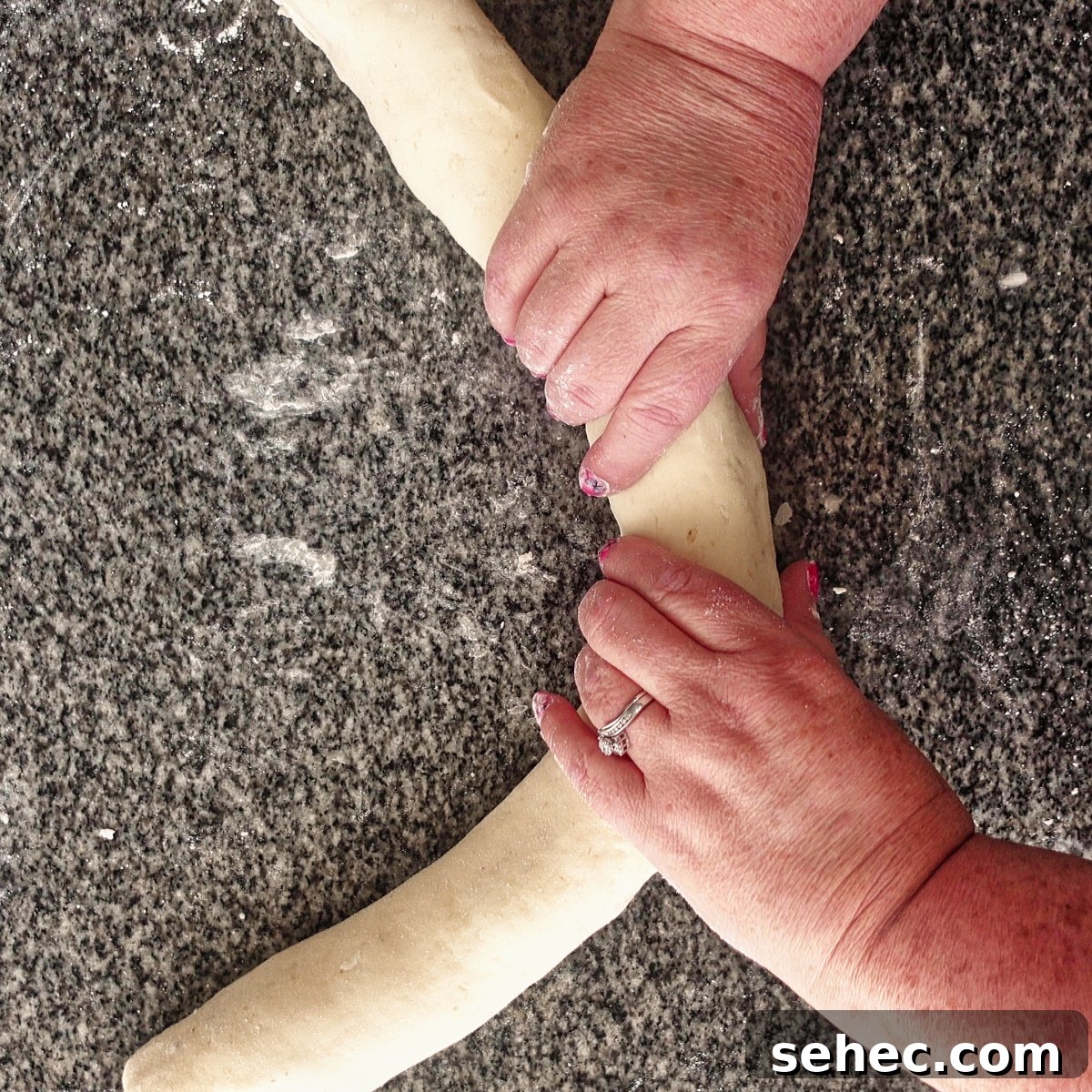 Gluten Free King Cake Recipe for Mardi Gras 13 elongating the log of dough.