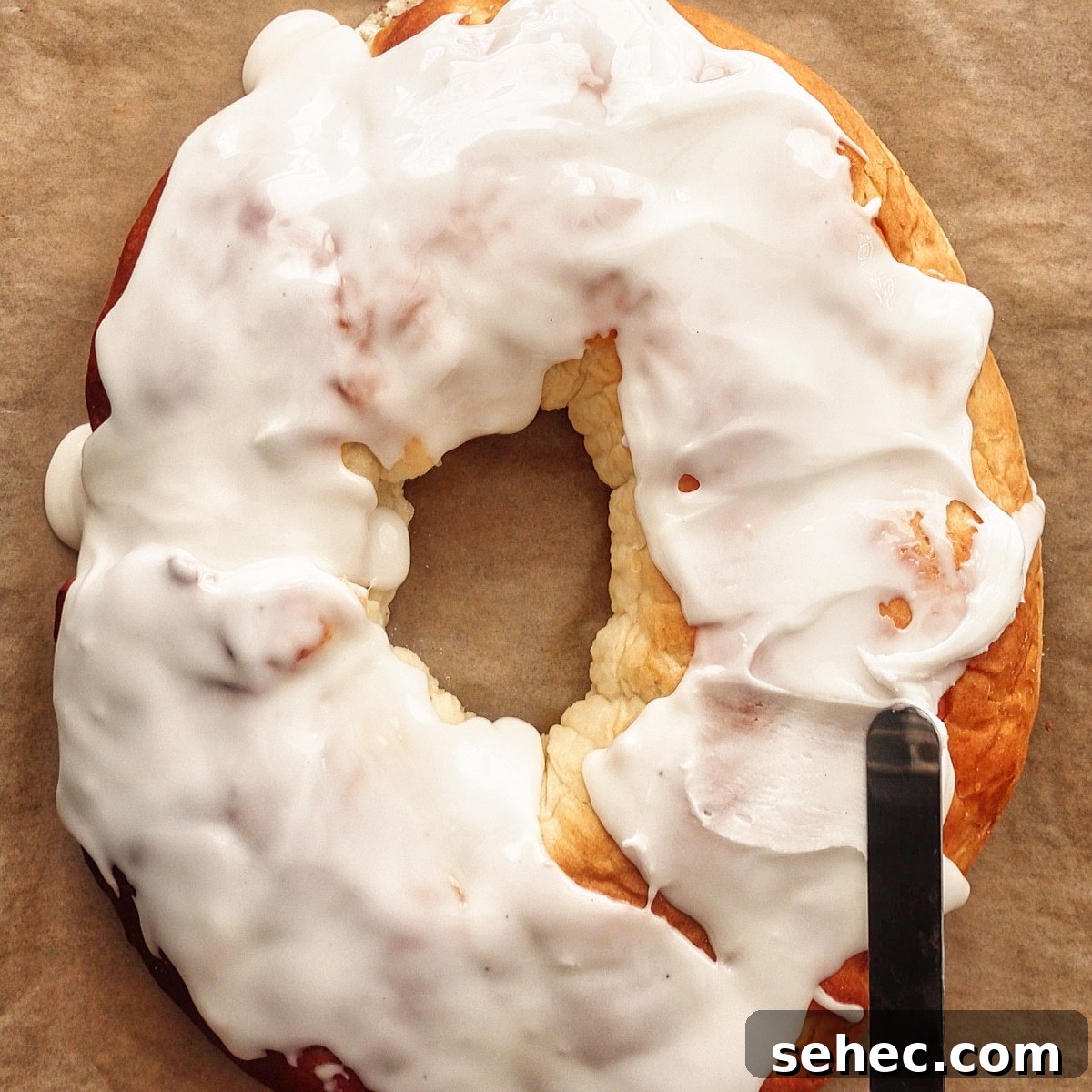 Gluten Free King Cake Recipe for Mardi Gras 16 Spreading icing onto warm baked king cake.