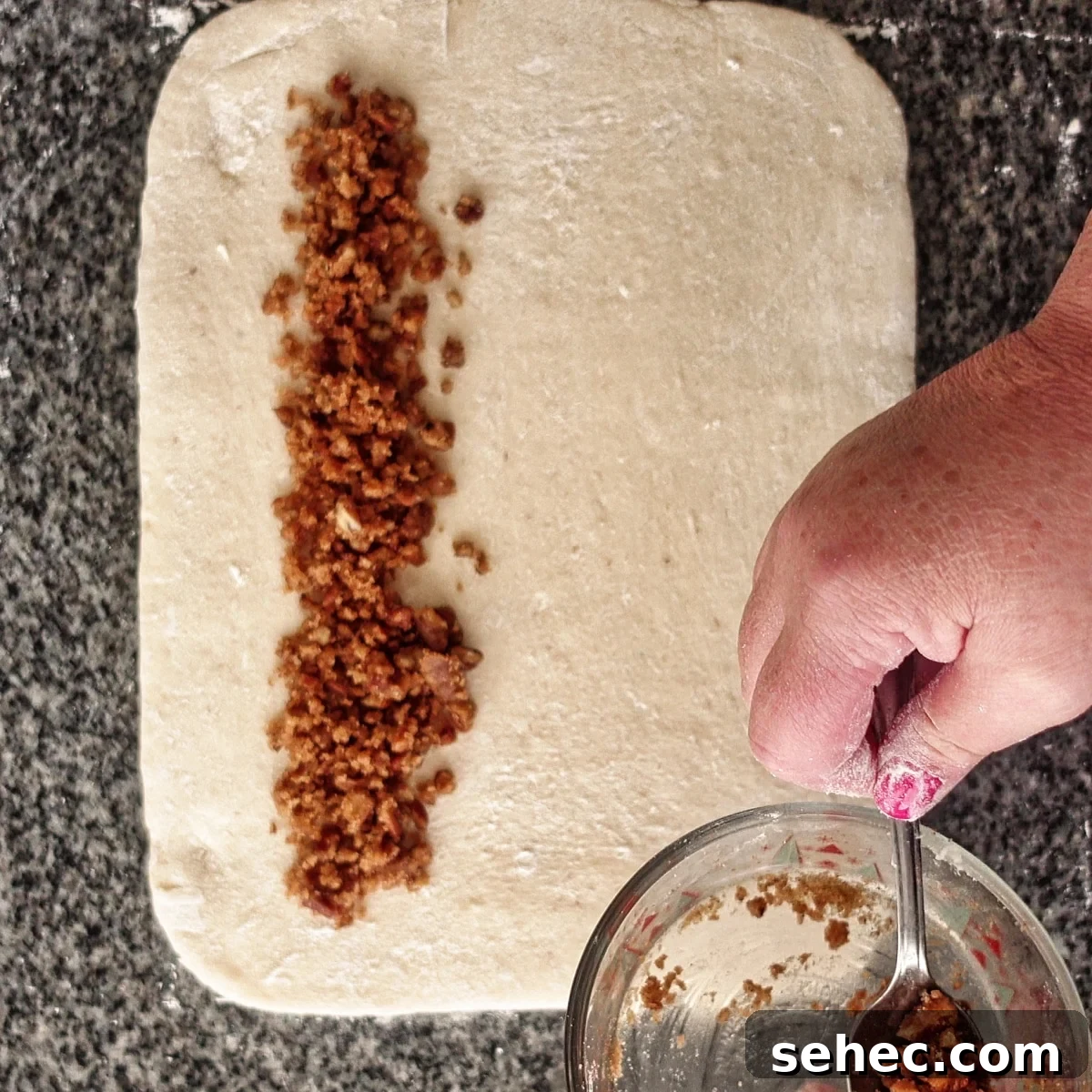 Gluten Free King Cake Recipe for Mardi Gras 10 placing praline filling in a line along one edge of the rectangle of dough.